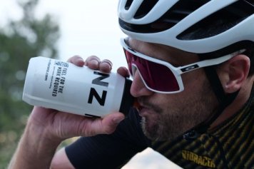 Cyklista pije sacharidový nápoj během závodu